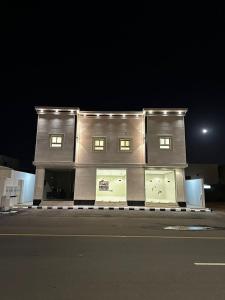a building with three windows on a street at night at شقق وغرف الرصف in Hail