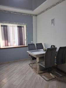 a dining room with a table and chairs and a window at MODEST in Slavske