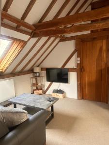 a living room with a couch and a flat screen tv at The Granary in Hurstpierpoint