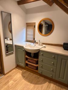 a bathroom with a sink and a mirror at The Granary in Hurstpierpoint +45 photos