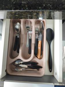 a plastic tray with utensils in a drawer at Yama Hospedagem e Moradia in Paranavaí