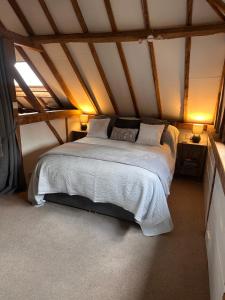 a bedroom with a large bed in a attic at The Granary in Hurstpierpoint