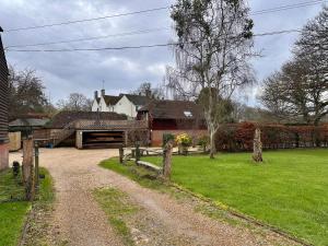 a house with a fence and a dirt road at The Granary in Hurstpierpoint
