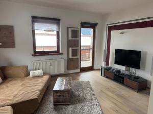 a living room with a couch and a flat screen tv at Appartement Muller-Mayer in Weissensee