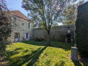 an old stone building with a tree in the yard at Gîte de Navarre in Billy