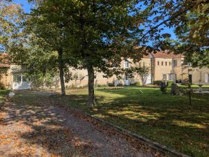a path in front of a large building with trees at Gîte de Navarre in Billy
