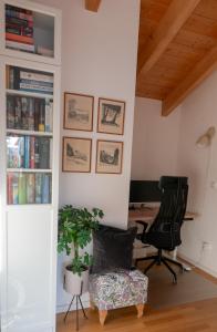an office with a desk and two chairs and a book shelf at Servus Chiemgau - Große Wohnung mit Bergblick in Frasdorf
