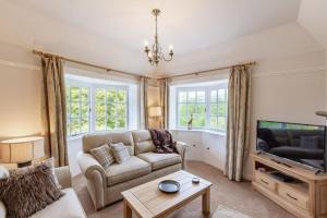 a living room with a couch and a tv at Lonan Country House and Gardens in Taynuilt