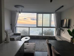 a living room with a view of the ocean at sea view apartment in Bat Yam
