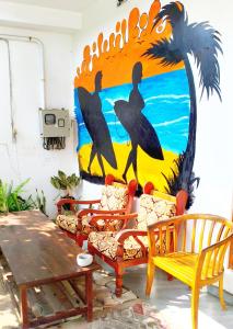 a mural of birds on a wall with chairs and a table at Costels Mirissa in Mirissa +32 photos