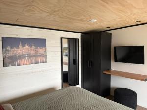 a bedroom with a bed and a tv on a wall at R&M Boutique in Lijnden