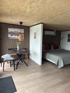 a bedroom with a bed and a desk and a table at R&M Boutique in Lijnden