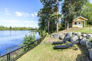 a couple of lawn chairs sitting next to a lake at Ferienhaus Valle-Sjötomt Borshult in Diö +31 photos