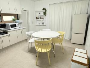 a kitchen with a white table and yellow chairs at 휘게스테이 in Sejong