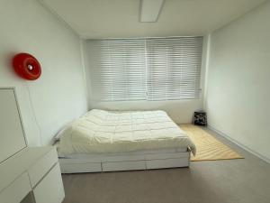 a white bedroom with a bed and a window at 휘게스테이 in Sejong