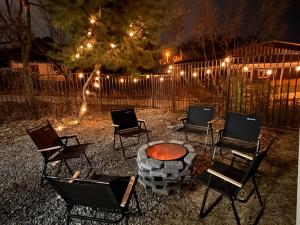 a group of chairs around a fire pit at night at 휘게스테이 in Sejong