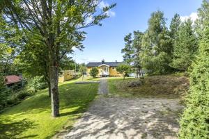 a yard with a house and a tree at Ferienhaus Valle-Sjötomt Borshult in Diö