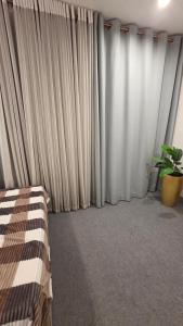 a bedroom with curtains and a bed with a plant at Sea esta villa in Mount Lavinia +9 photos