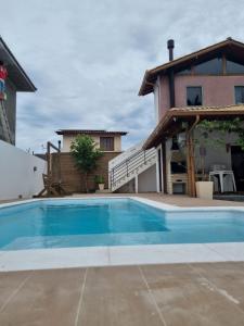 a swimming pool in front of a house at Cabanas da Vó Nena in Palhoça