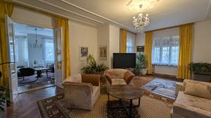 a living room with a couch and chairs and a television at Pension Central in Ústí nad Labem