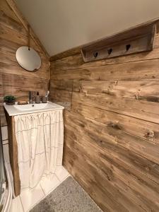 a bathroom with a sink and a wooden wall at Valhalla Hytte in Oppdal +40 photos
