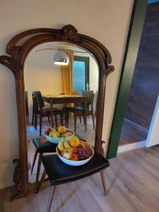 a table with two bowls of fruit in front of a mirror at Chalet De Maanvaren in Hattemerbroek