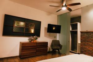 a bedroom with a bed and a tv and a chair at Hotel Boutique in Querétaro +4 photos
