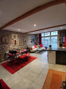 a kitchen and living room with a stone wall at La Belle Maison in Piégut-Pluviers