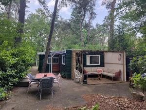 a green caravan with a patio and a table and chairs at Chalet De Maanvaren in Hattemerbroek +32 photos