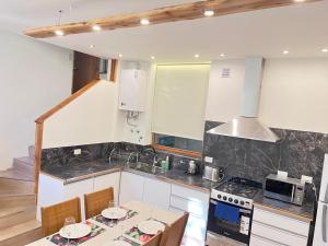 a kitchen with a table and a stove top oven at Tranquila y moderna en el bosque in San Carlos de Bariloche