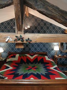 a bed with a colorful comforter on top of it at La Belle Maison in Piégut-Pluviers +11 photos
