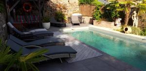 a swimming pool with chaise lounge chairs and a swimming pool at La Belle Maison in Piégut-Pluviers