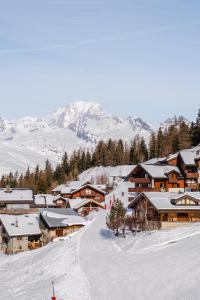 a ski resort in the snow with mountains in the background at Hotel Emeraude in Peisey-Nancroix