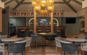 a restaurant with tables and chairs and a bar at Fairview Hotel Nairobi, Vignette Collection by IHG in Nairobi