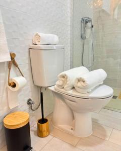 a bathroom with a toilet and a shower with towels at Casa do Pastor - Vale de Alfaia in Sobral do Campo +9 photos