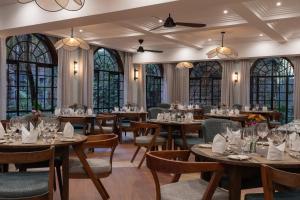 a dining room with tables and chairs and windows at Fairview Hotel Nairobi, Vignette Collection by IHG in Nairobi