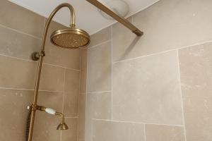 a shower with a shower head in a bathroom at La Maison des Templiers in Couches