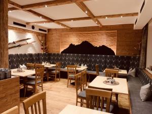 a dining room with tables and chairs and a brick wall at Haus Greif in Weissenbach am Lech