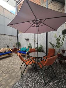 a table with chairs and an umbrella on a patio at Magnolia Andina Hostel in Cusco