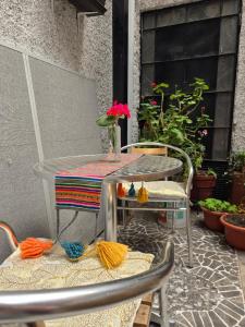 a table and chairs on a patio with flowers on it at Magnolia Andina Hostel in Cusco