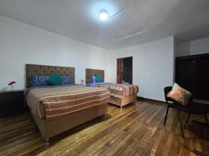 a bedroom with two beds and a flat screen tv at Magnolia Andina Hostel in Cusco