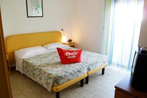 チェゼナーティコにあるB&B Domus Meaのベッドルーム1室(赤い枕付きのベッド1台付)
