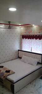 a bed in a room with a window and a bed frame at Maa durga lodge in Navadwīp