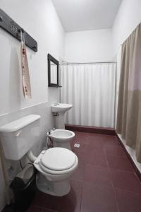 a bathroom with a white toilet and a sink at El Bosque de Simba - Casa in La Estancia +8 photos