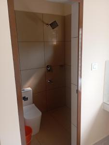 a bathroom with a toilet and a shower at PURAYIL Rooms in Kozhikode +1 photo