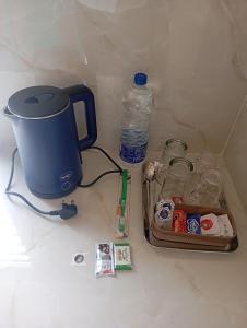 a table with a coffee maker and a bottle of water at PURAYIL Rooms in Kozhikode