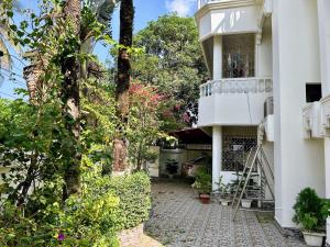 a view of a building with a balcony and trees at Sribhumi Homestay in Sreemangal
