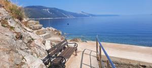 a bench sitting next to a body of water at Apartment Djanina in Cres