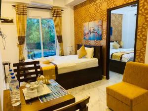 a bedroom with two beds and a table and a chair at Ivory Laze Hotel in Negombo +86 photos