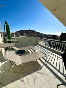 a balcony with a table and chairs on a roof at Vista Kavala Center in Kavála